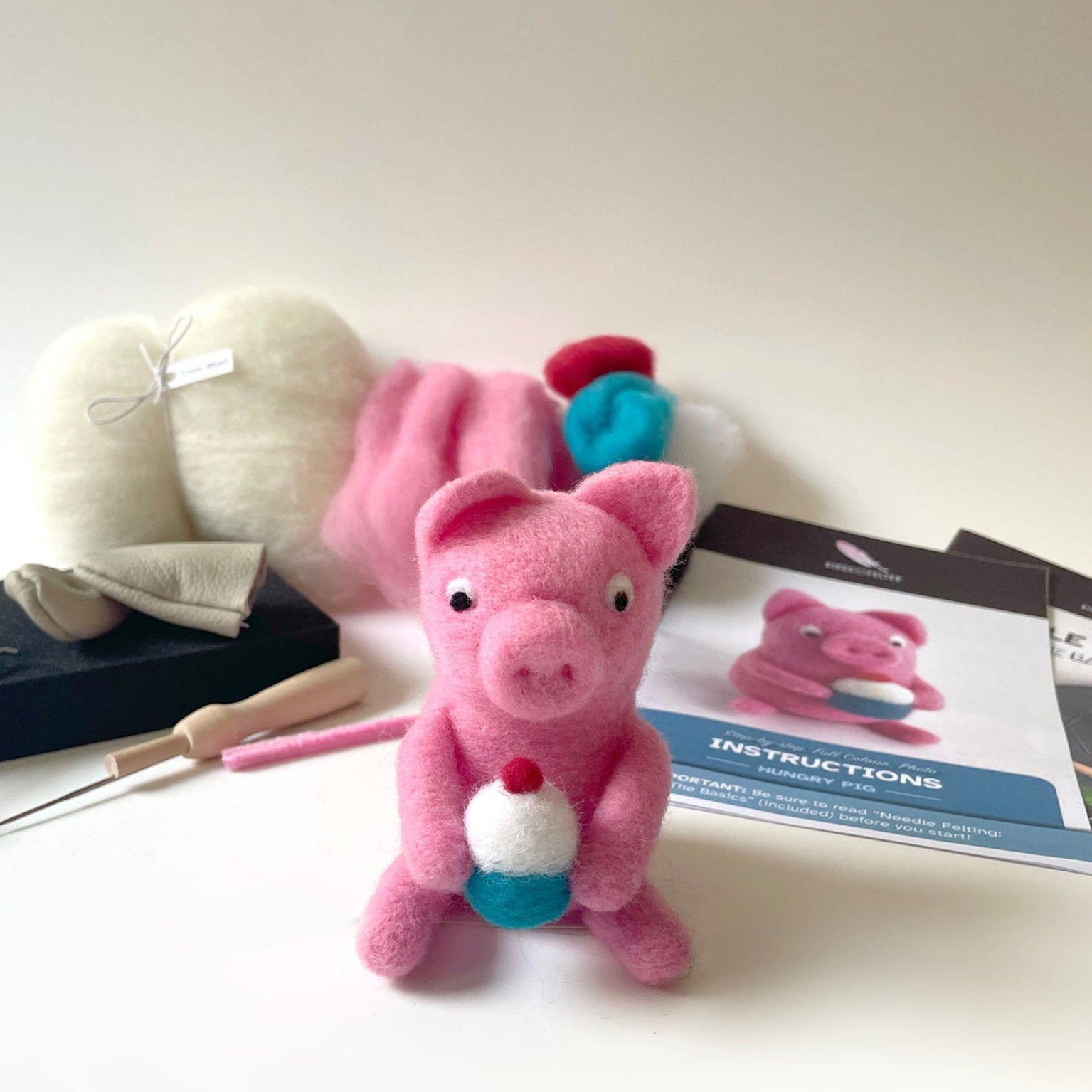 Pink plush pig toy with tools and instructions on a white background